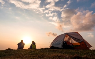 Bivouac au coucher du soleil entre deux amis à côté de leur tente